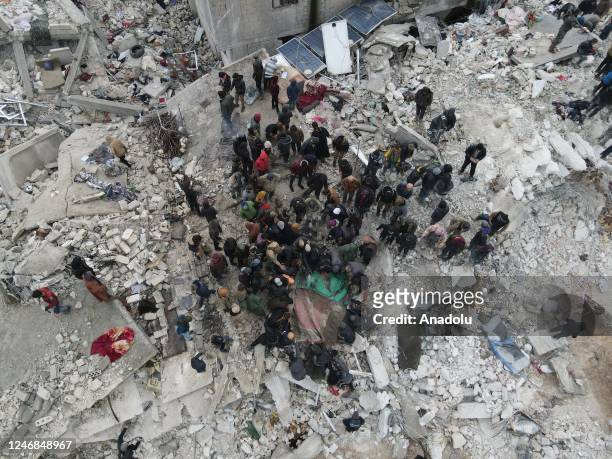 An aerial view of a collapsed buildings as personnel and civilians conduct search and rescue operations in Idlib, Syria after 7.7 and 7.6 magnitude...