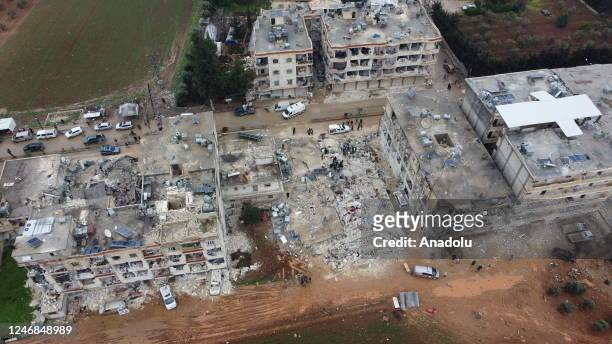 An aerial view of a collapsed buildings as personnel and civilians conduct search and rescue operations in Cenderes district of Aleppo, Syria after...