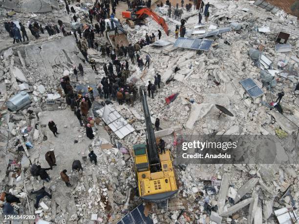 An aerial view of a collapsed buildings as personnel and civilians conduct search and rescue operations in Idlib, Syria after 7.7 and 7.6 magnitude...