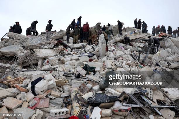 Residents and rescuers search for victims and survivors amidst the rubble of collapsed buildings following an earthquake in the village of Besnaya in...