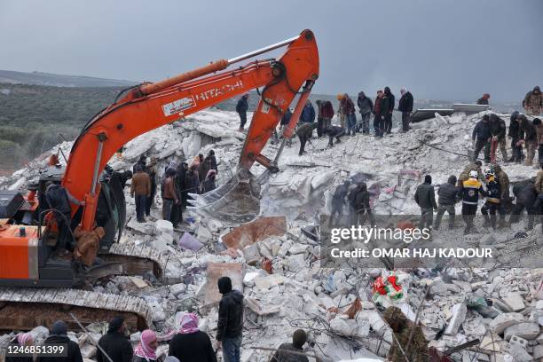 Residents and rescuers search for victims and survivors amidst the rubble of collapsed buildings following an earthquake in the village of Besnaya in...