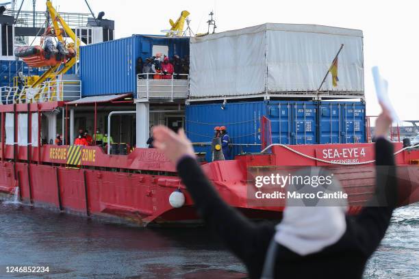 Woman greets migrants before disembarking in Naples from the Sea-Eye 4 rescue vessel after being rescued from a shipwreck in the Mediterranean Sea.