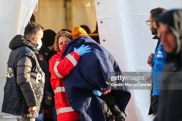 Migrant child with a rescuer during the checks after disembarking in Naples, from the rescue ship Sea-Eye 4, after being rescued from a shipwreck in...