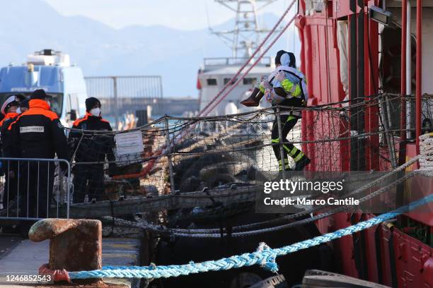 Migrant, carried in the arms of a rescuer, disembarks in Naples, from the Sea-Eye 4 rescue ship, after being saved from a shipwreck in the...