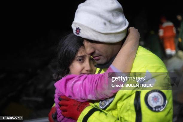Police officer Zekeriya Yildiz hugs his daughter after they saved her from the rubble in Hatay on February 6 after a 7.8-magnitude earthquake struck...