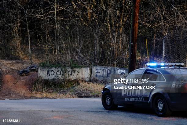 Law enforcement drive past the planned site of a police training facility that activists have nicknamed "Cop City", following the first raid since...