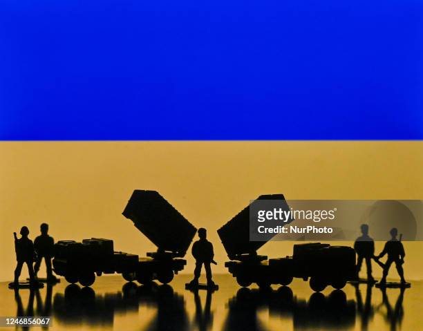 Illustration of a mini replica of MIM-104 Patriot, a surface-to-air missile system and and figures of soldats, seen in front of the Ukrainian...