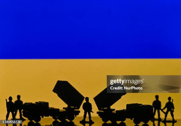 Illustration of a mini replica of MIM-104 Patriot, a surface-to-air missile system and and figures of soldats, seen in front of the Ukrainian...