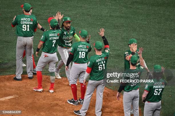 Mexico's Caneros de Los Mochis players celebrate after defeating Venezuela's Leones del Caracas during their Caribbean Series game at the Monumental...