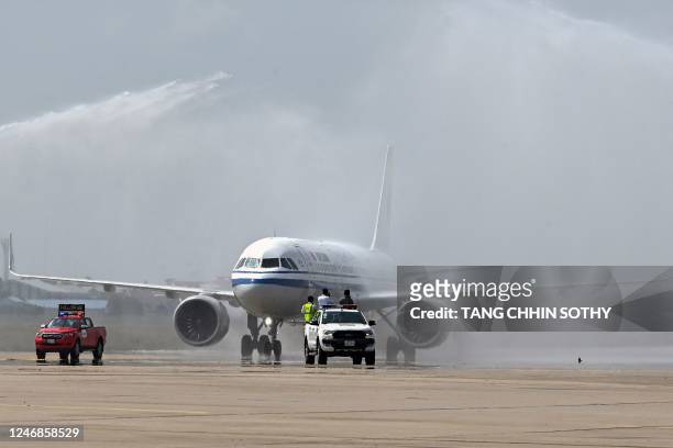 An Air China passenger plane is given a water cannon salute during a welcoming ceremony at Phnom Penh International Airport in Phnom Penh on February...