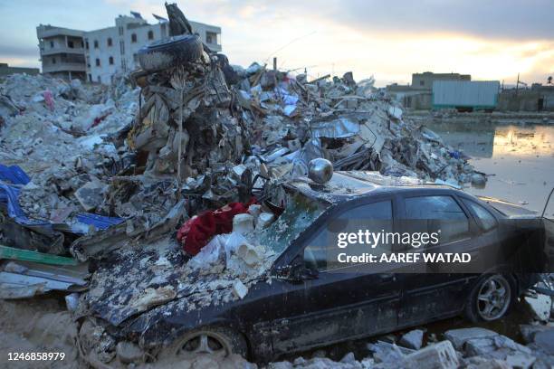 Car sits under the rubble of a collapsed building on February 6, 2023 in the town of Sarmada, in Syria's rebel-held northwestern Idlib province,...