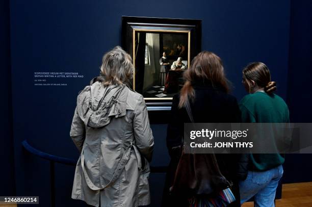 Women takes a photo of a painting by the Dutch painter Johannes Vermeer titled, 'Women writting a letter, with her maid', at the Rijksmuseum, in...