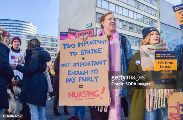 Nurse holds a placard that states "Too important to strike, not important enough to pay fairly" during the demonstration at the picket outside St...