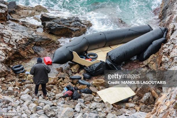 Man stands next to a rubber boat, believed to be used by migrants, in Thermi on the Greek island of Lesbos on February 7, 2023. - Three migrants died...