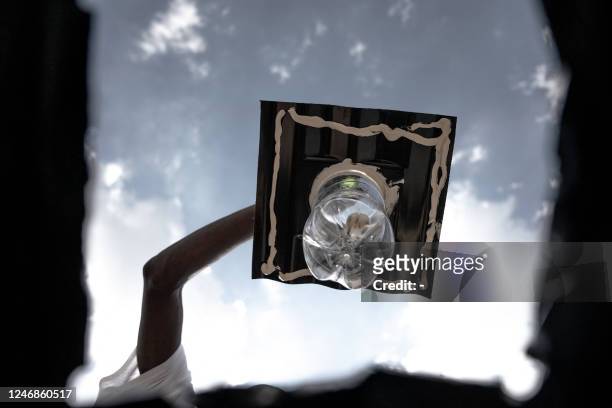 Workers install the Amandla Elanga bottle globe on the roof of a shack in an informal settlement in Olievenhoutbosch, Centurion, on February 6, 2023....