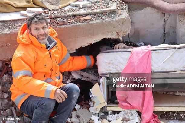 Mesut Hancer holds the hand of his 15-year-old daughter Irmak, who died in the earthquake in Kahramanmaras, close to the quake's epicentre, the day...