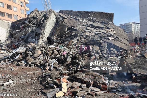 Man sits on the rubble of a collapsed buildings in Kahramanmaras, close to the quake's epicentre, the day after a 7.8-magnitude earthquake struck the...