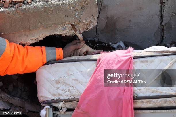 Mesut Hancer holds the hand of his 15-year-old daughter Irmak, who died in the earthquake in Kahramanmaras, close to the quake's epicentre, the day...