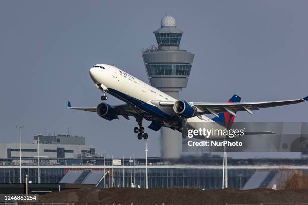 Delta Air Lines Airbus A330 aircraft as seen during take off and flying phase, passing in front of the air traffic control tower while the plane is...