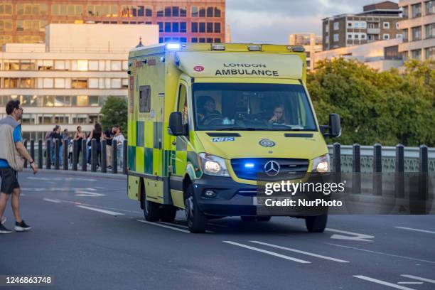 Yellow ambulance spotted on Westminster Bridge, an emergency service vehicle with paramedics of the National Health Service NHS in motion on the...