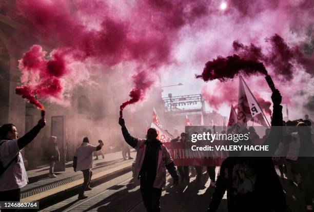 Protesters, holding smoke flares, participate in a demonstration on the third day of nationwide rallies organised since the start of the year,...