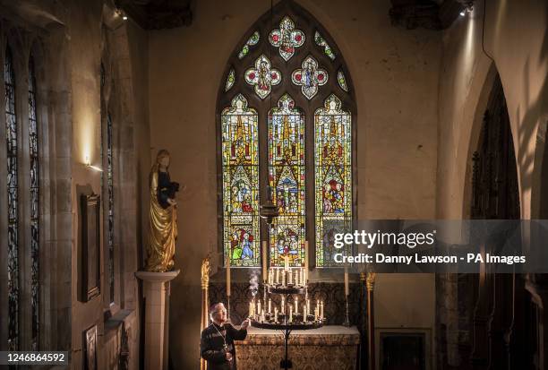 The Rt Reverend Glyn Webster lights a candle in front of the newly restored Lady Chapel East Window at All Saints North Street in York, one of...