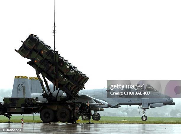 Airforce OA-10 airplane passes near a Patriot PAC-2 missile system at the South Korean airforce base in Suwon 18 September 2003. The United States is...