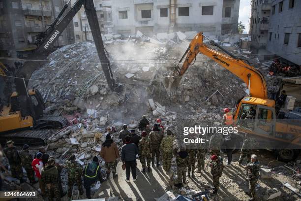 Rescue workers search for survivors in the rubble of a collapsed building in the town of Jableh in Syria's northwestern province of Latakia following...