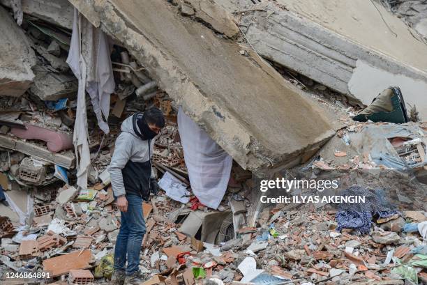 Man inspects the rubble as rescuers search for victims and survivors, a day after a 7.8-magnitude earthquake struck the country's southeast, in...