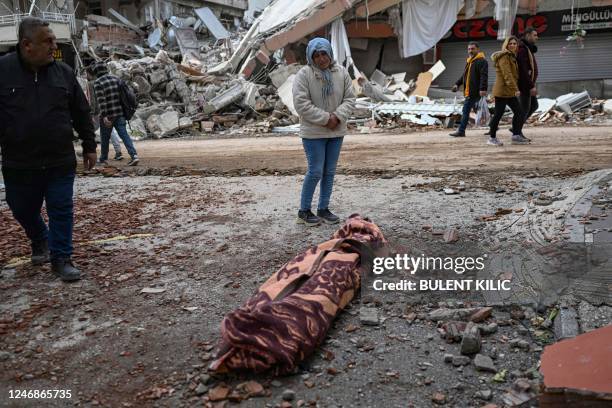 Woman weeps as she stands beside the body of a victim in Hatay on February 7 a day after a 7,8-magnitude earthquake struck the country's southeast. -...