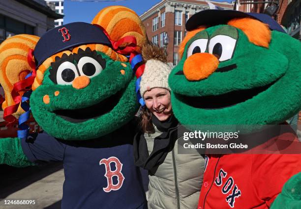 Boston, MA A Boston Red Sox fan poses for a photo with the teams mascots Wally and Tessie during the teams annual equipment truck day.