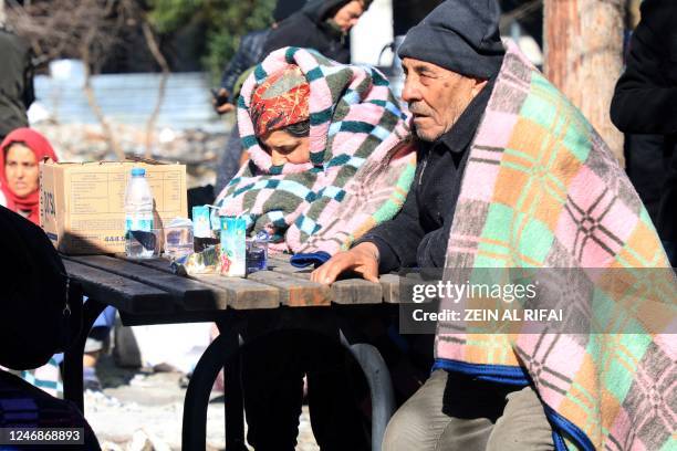 An elderly couple sit at a table in a park in Gaziantep, close to the quake's epicentre, a day after a 7.8-magnitude earthquake struck the country's...