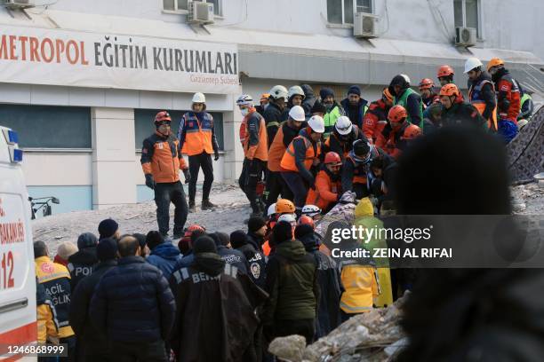 Rescuers evacuate a victim retrieved in the rubble of collapsed buldings in Gaziantep, close to the quake's epicentre, a day after a 7.8-magnitude...