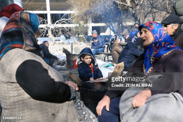 People warm up around a fire in a park in Gaziantep, close to the quake's epicentre, a day after a 7.8-magnitude earthquake struck the country's...
