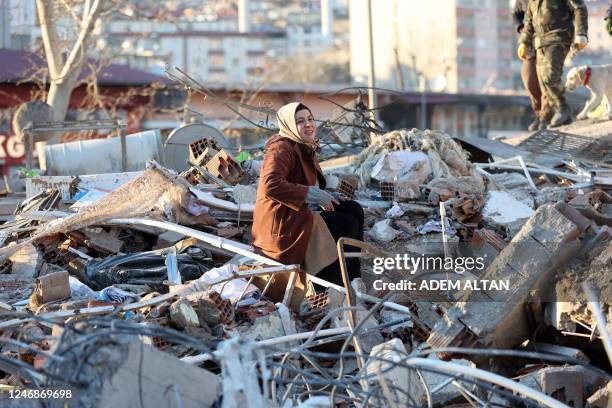 Woman sits on the rubble of a destroyed building in Kahramanmaras, southern Turkey, a day after a 7.8-magnitude earthquake struck the country's...