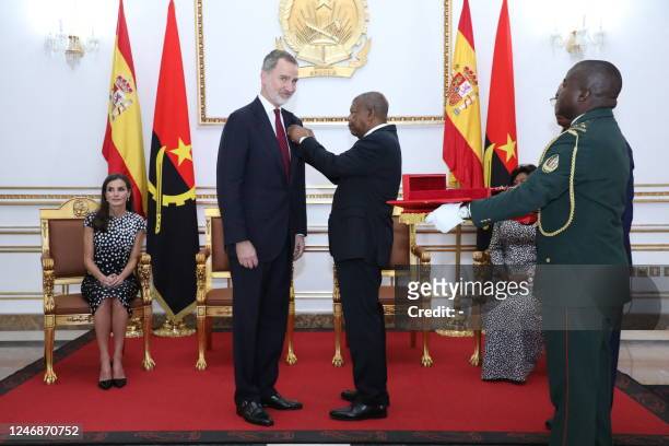 King Felipe VI of Spain looks on as Angolan President Joao Manuel Goncalves Lourenco pins a decoration on his lapel as Queen Letizia of Spain and...