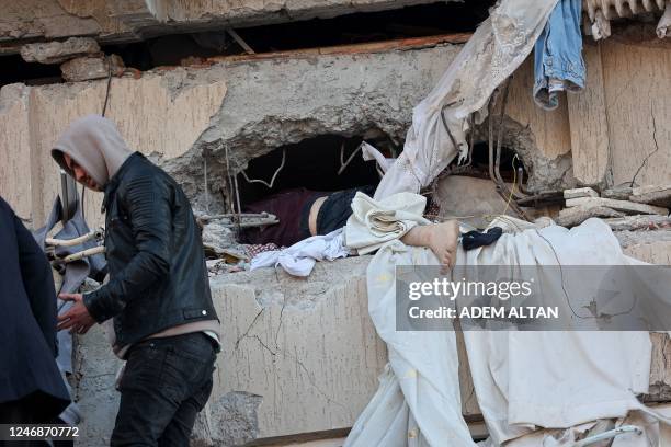 Graphic content / TOPSHOT - The body of a deceased victim lies entangled in the wreckage of a destroyed building in Kahramanmaras on February 7 after...