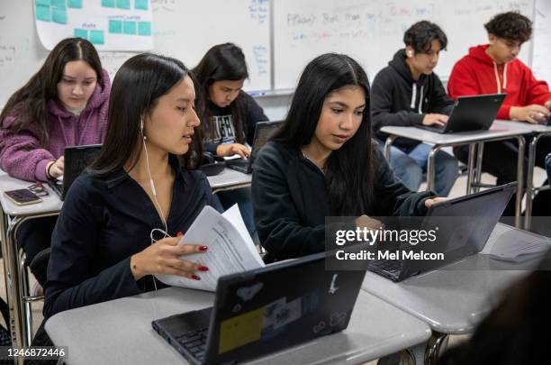 Vianney Silva-Mercado, left, and Jenny Cisneros, 10th graders at Birmingham High School in Van Nuys, go over an assignment on their computer screens...