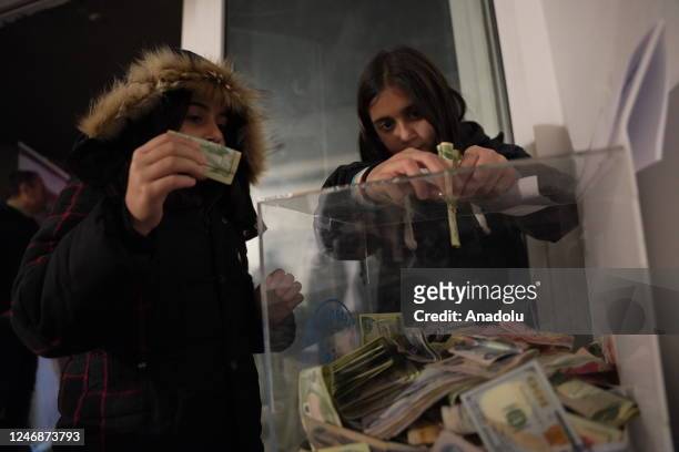 Iraqi people collect money in donation boxes to be sent for the victims of the devastating earthquakes in Turkiye as part of aid campaigns in...