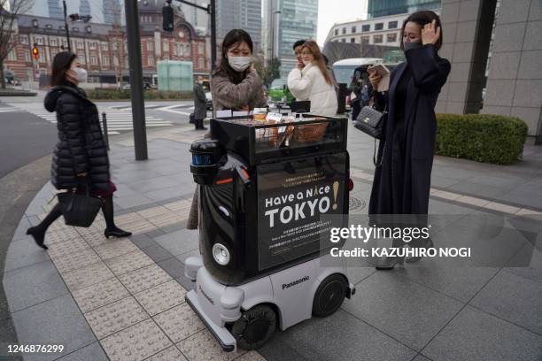 This picture taken on January 13, 2023 shows Panasonics delivery robot Hakobo selling hot drinks and snacks in Tokyo's shopping and business area of...