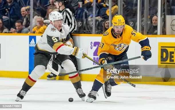 Dante Fabbro of the Nashville Predators battles for the puck against Jack Eichel of the Vegas Golden Knights during an NHL game at Bridgestone Arena...