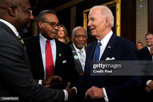 President Joe Biden shakes hands with Sen. Raphael Warnock as Rep. Emanuel Cleaver looks on after delivering the State of the Union address on...