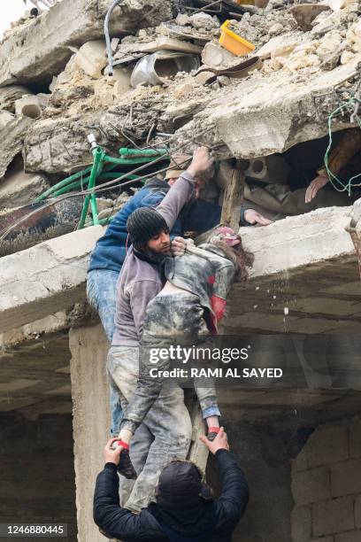 In this picture taken on February 6 residents rescue an injured girl from the rubble of a building that collapsed due to an earthquake in Jindayris,...