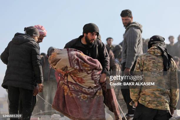 Graphic content / A Syrian man carries the body of a child on February 7 in the town of Jindayris, in the rebel-held part of Aleppo province, as...
