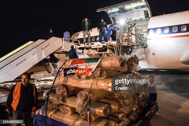 Workers unload aid sent by Iran by plane, at the airport in Syria's northern city of Aleppo early on February 8 following a deadly earthquake. - The...