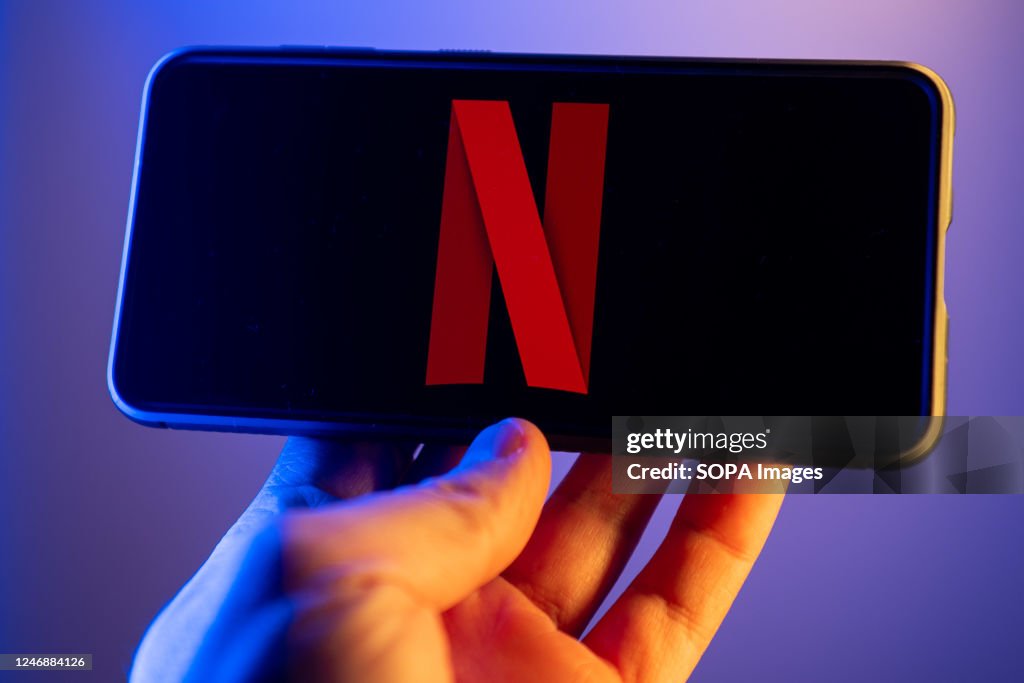 In this photo illustration, a Netflix logo seen displayed on...
