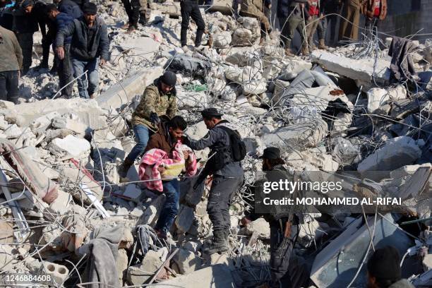 Man carries the body a child pulled out from the rubble in the town of Harim, in Syria's rebel-held northwestern Idlib province on the border with...