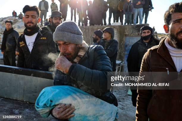 Man carries the body of his baby pulled out from the rubble in the town of Harim, in Syria's rebel-held northwestern Idlib province on the border...