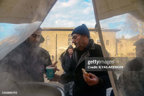 People are served a hot drink near the historical Grand Mosque, two days after a strong earthquake struck the region, in the southeastern Turkish...