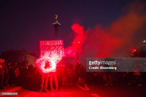 Demonstrators let off a flare at the end a protest march at Place de Bastille during a national strike against government plans to revamp the pension...